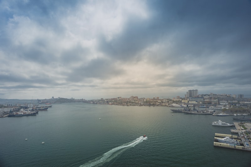 white boat on sea near city buildings during daytime